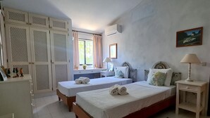 A bedroom with two beds, a desk, a wardrobe, and a window with curtains. - Dunas Douradas Beach Villa (Vale do Lobo)