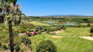 A golf course with multiple holes, water bodies, and surrounding greenery. - Dunas Douradas Beach Villa (Vale do Lobo)