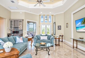 A spacious living room with a large sofa, a coffee table, and a television.