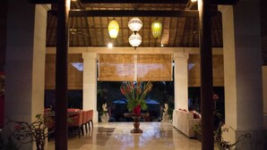 An indoor lobby with a central fountain, seating areas, and decorative lighting. - Villa Pasraman Baghawan (Jimbaran)