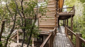 Una cabaña de madera con un muelle de madera y un balcón pequeño.