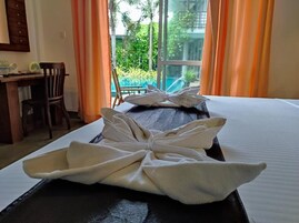 Una habitación de hotel con cama, escritorio y vista a una piscina.