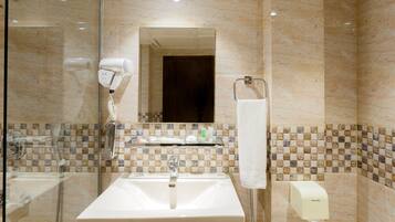 A bathroom with a sink, mirror, hairdryer, towel rack, and a soap dispenser.