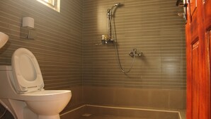 A bathroom with a toilet, a shower, and a sink. - Saltek Forest cottages (Masindi)