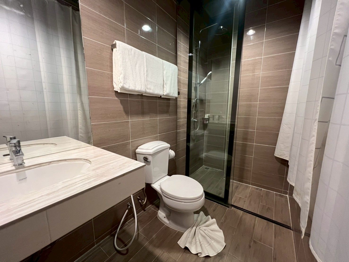 Un baño moderno con ducha, inodoro y lavamanos.
