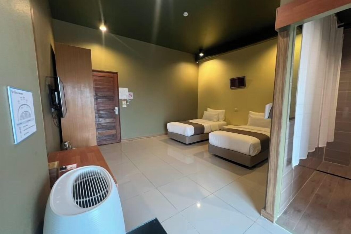 A hotel room with a bed, a desk, and a bathroom.