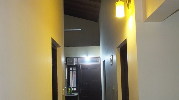 A narrow hallway with yellow walls and a door at the end. - Hillsview Rest and Guest House (Matale)