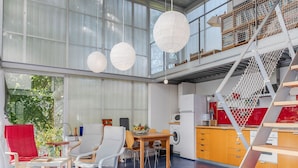 A modern interior with a dining area, kitchen, and a staircase with a unique design.