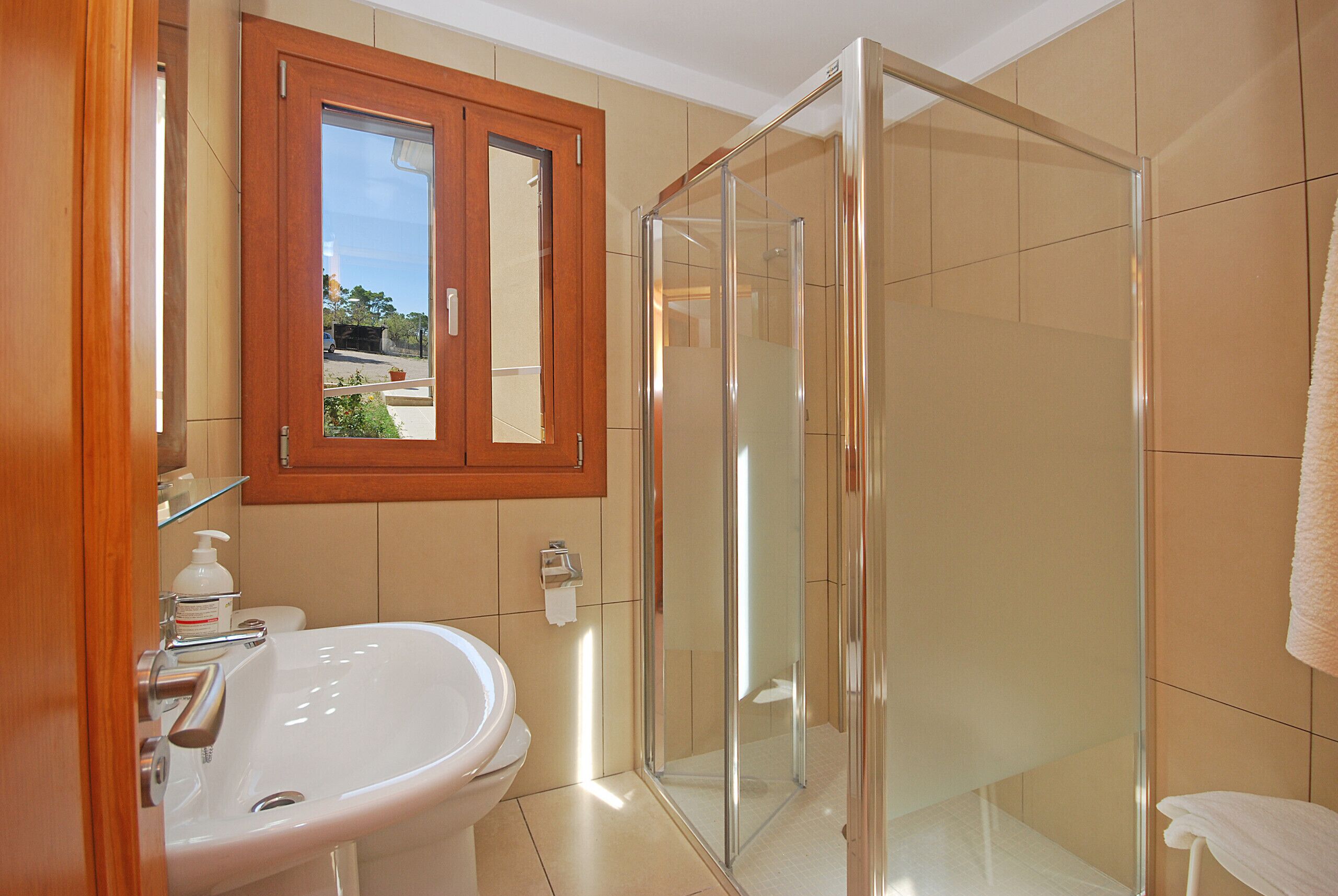 Une salle de bain avec un lavabo, un miroir et une douche en verre.