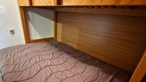 A single bed with a brown quilt in a small room with wooden walls and a window. - Cozy Studio with Cabin for 4/5 People, Near Ski Lifts - Modane, France (Valfréjus)