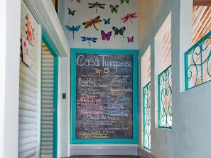 A chalkboard menu listing breakfast, lunch, dinner, and tours at Casa Turquesa.