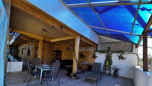 An outdoor patio with a blue canopy, tiled flooring, and furniture. - A peaceful apartment in sun house Puerto Vallarta (Lomas del Calvario)