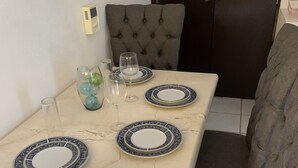 A dining table set with plates, glasses, and a vase. - A peaceful apartment in sun house Puerto Vallarta (Lomas del Calvario)