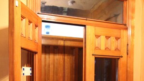 A wooden double door with a small window, leading to a hallway with wooden flooring. - Historic Home With Modern Amenities - Great for Families with room for up to 18! (Clear Lake)