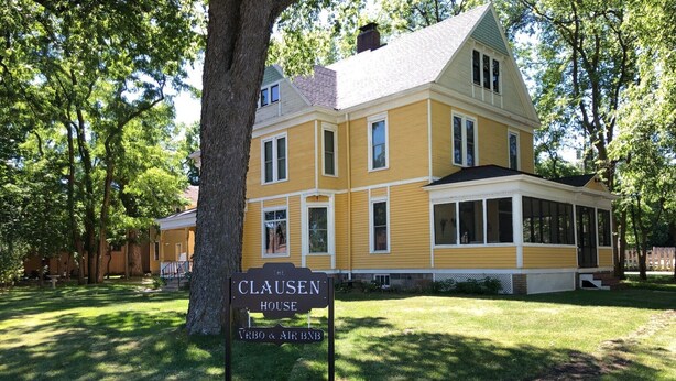 A yellow house with a sign that reads "The Clausen House." - Historic Home With Modern Amenities - Great for Families with room for up to 18! (Clear Lake)