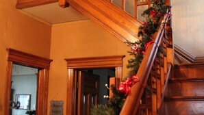 A wooden staircase with a garland decorated with red berries and greenery. - Historic Home With Modern Amenities - Great for Families with room for up to 18! (Clear Lake)