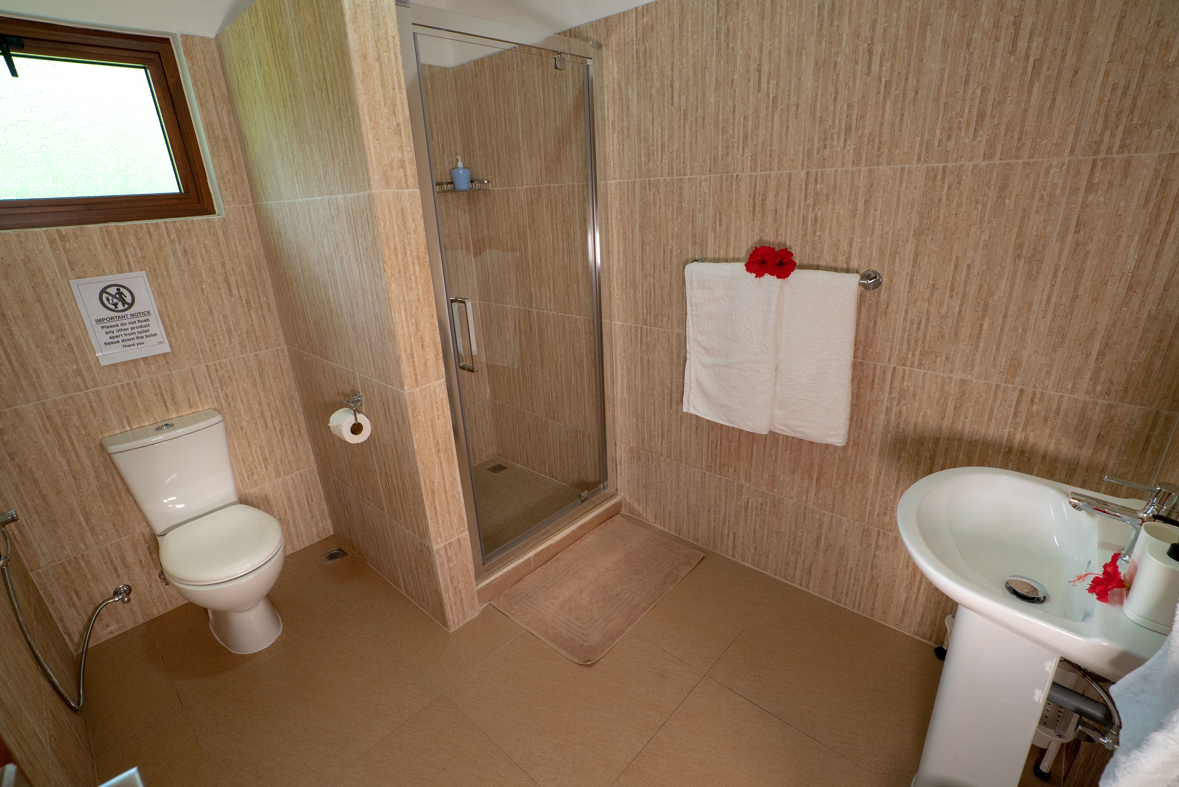 A bathroom with a toilet, shower, and sink.