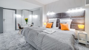 Un dormitorio moderno con una cama grande, un tocador con espejo y una silla.