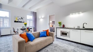 Una sala moderna con sofá, comedor y cocina.