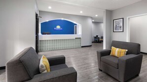 A reception area with a blue counter, two grey armchairs with yellow cushions, and a framed picture on the wall. - Days Inn by Wyndham North Little Rock/ Maumelle (North Little Rock)