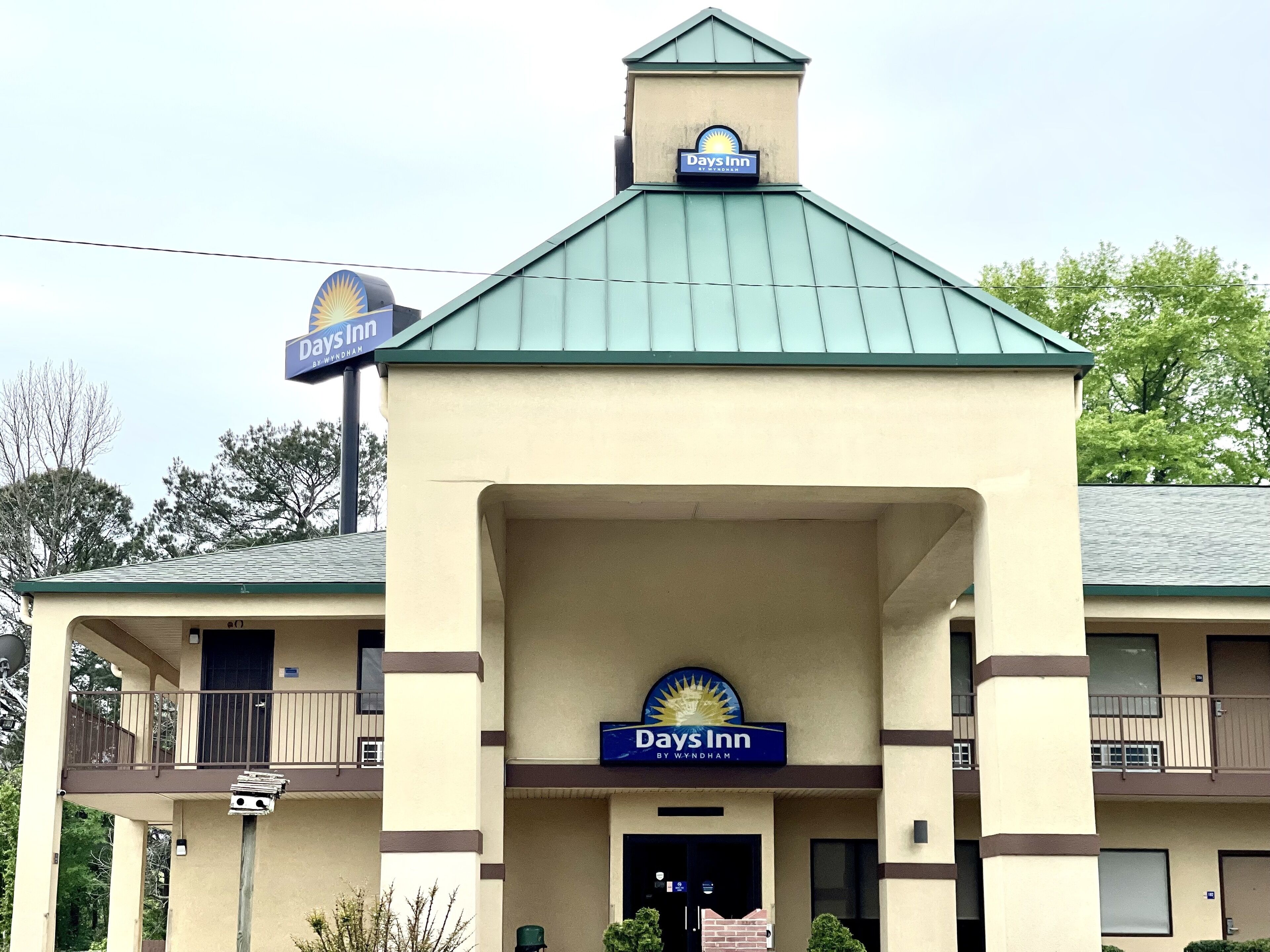 A Days Inn building with a green roof and a sign above the entrance.
