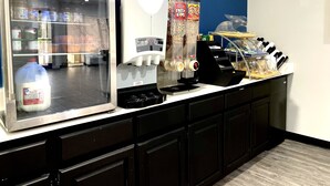 A self-service beverage station with a milk cooler, a coffee machine, and a cereal dispenser. - Days Inn by Wyndham North Little Rock/ Maumelle (North Little Rock)