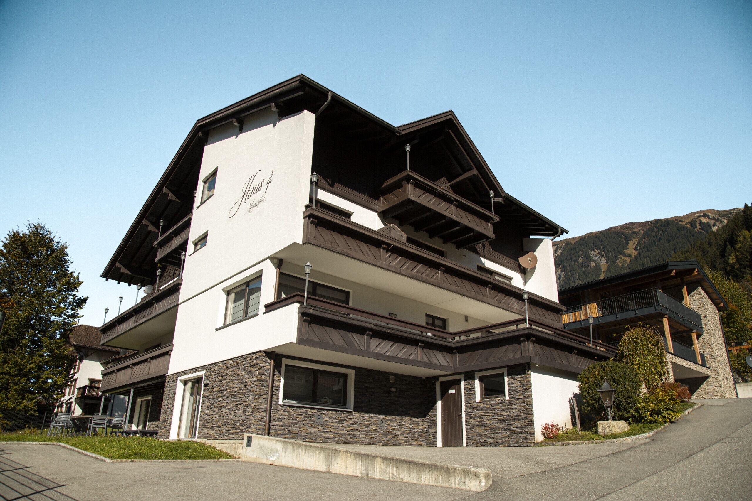 A multi-story hotel with a modern design, featuring balconies and a stone facade.