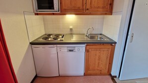 Una cucina compatta con fornello, lavello e lavastoviglie.