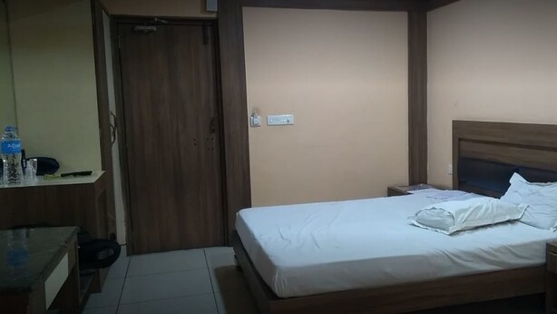 Un dormitorio pequeño y ordenado con una cama individual, una mesita de noche y un armario de madera.