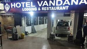 Entrada de un hotel con un cartel que dice 'HOTEL VANDANA LODGING & RESTAURANT'.
