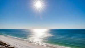 Ein Strand mit blauem Himmel und strahlender Sonne.