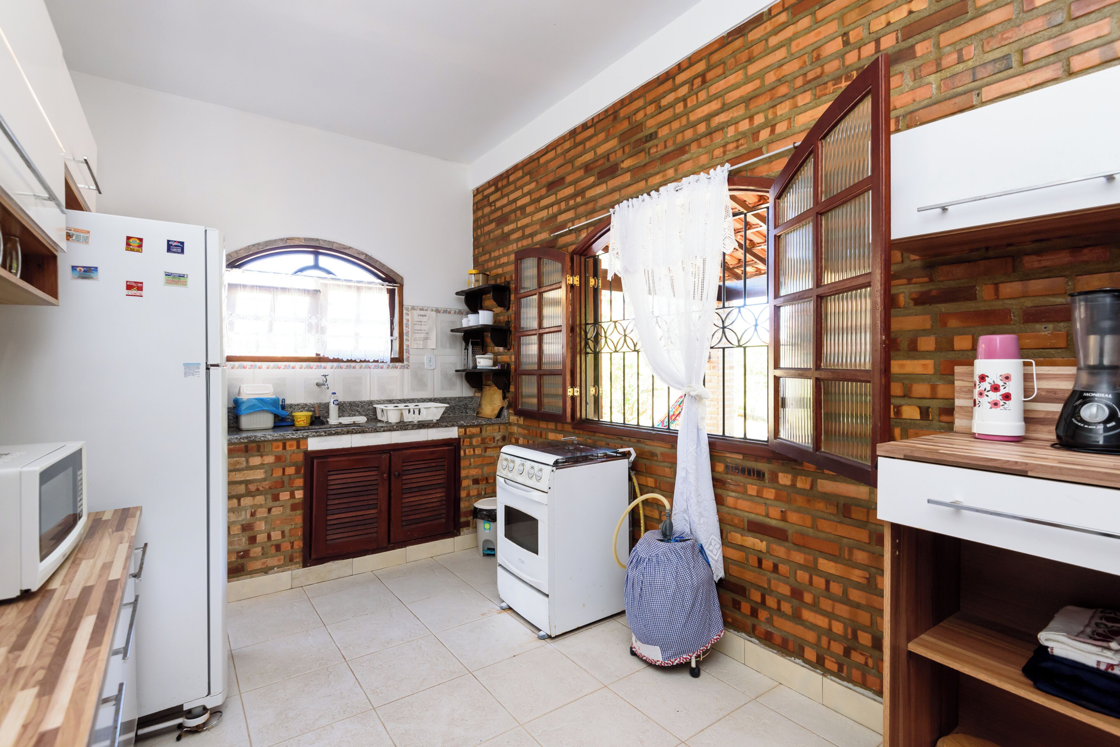 A compact kitchen with a refrigerator, stove, and microwave.