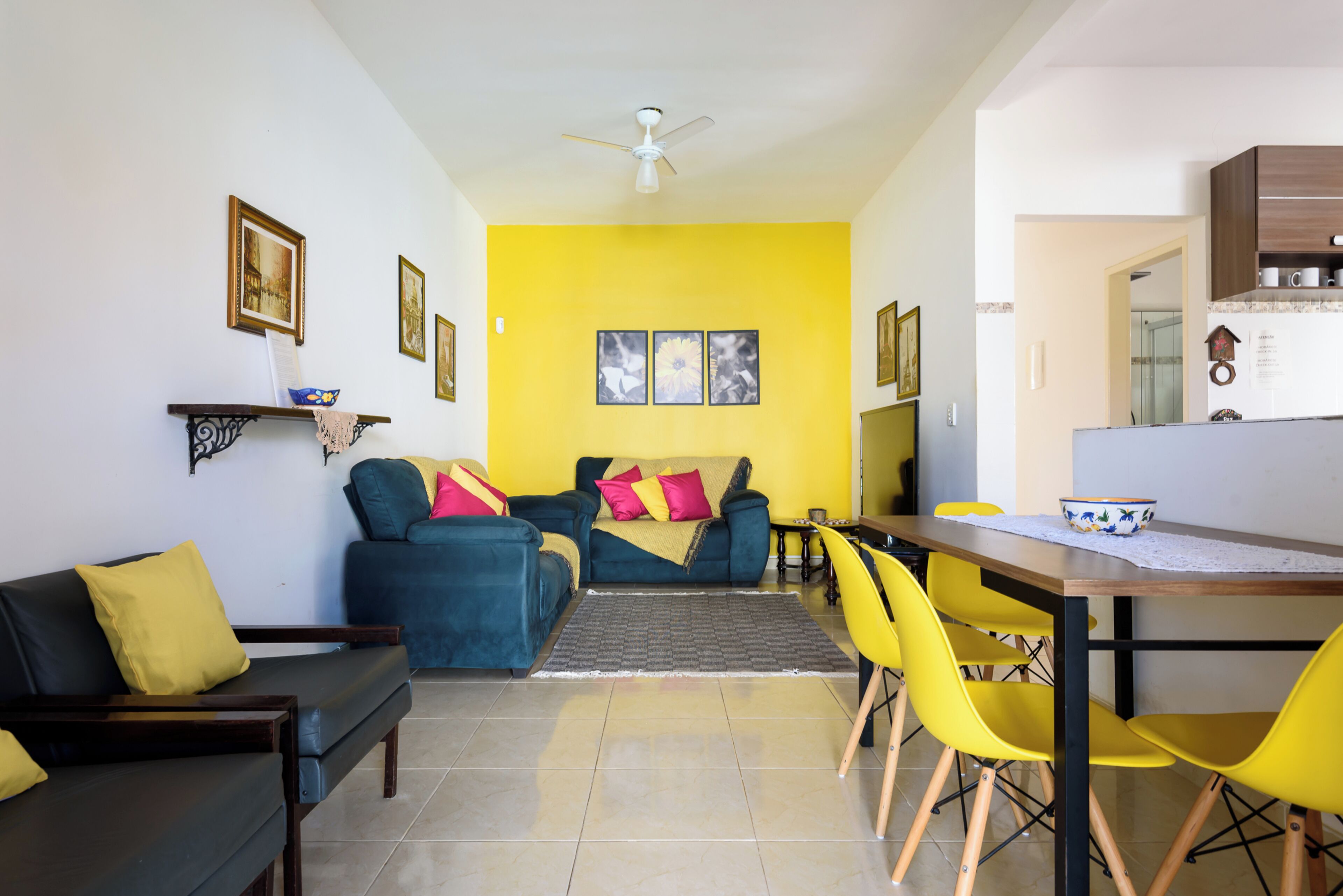 Una sala de estar con sofá, sillas, una mesa de comedor y una zona de cocina.