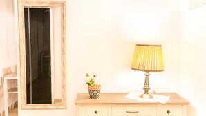 Een klein nachtkastje met een lamp en een bloempot.