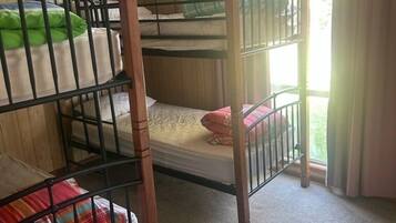 A bunk bed room with wooden walls and a carpeted floor.