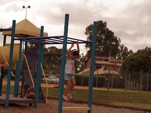 Un'area giochi con una struttura di arrampicata e uno scivolo.