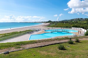 Um resort à beira-mar com piscina, acesso direto à praia e vista para o oceano.