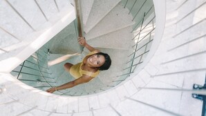 Una escalera de caracol con una persona bajando.