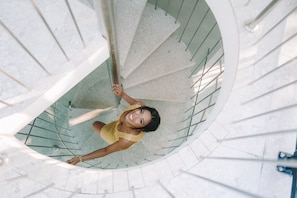 A spiral staircase with a person descending.