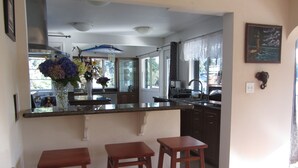 A kitchen with a large island, bar stools, and a vase of flowers. - Lake front - Upper floor - no animal- allergies  (Federal Way)
