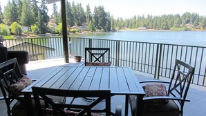 A patio with a table and chairs, overlooking a lake with houses in the background. - Lake front - Upper floor - no animal- allergies  (Federal Way)