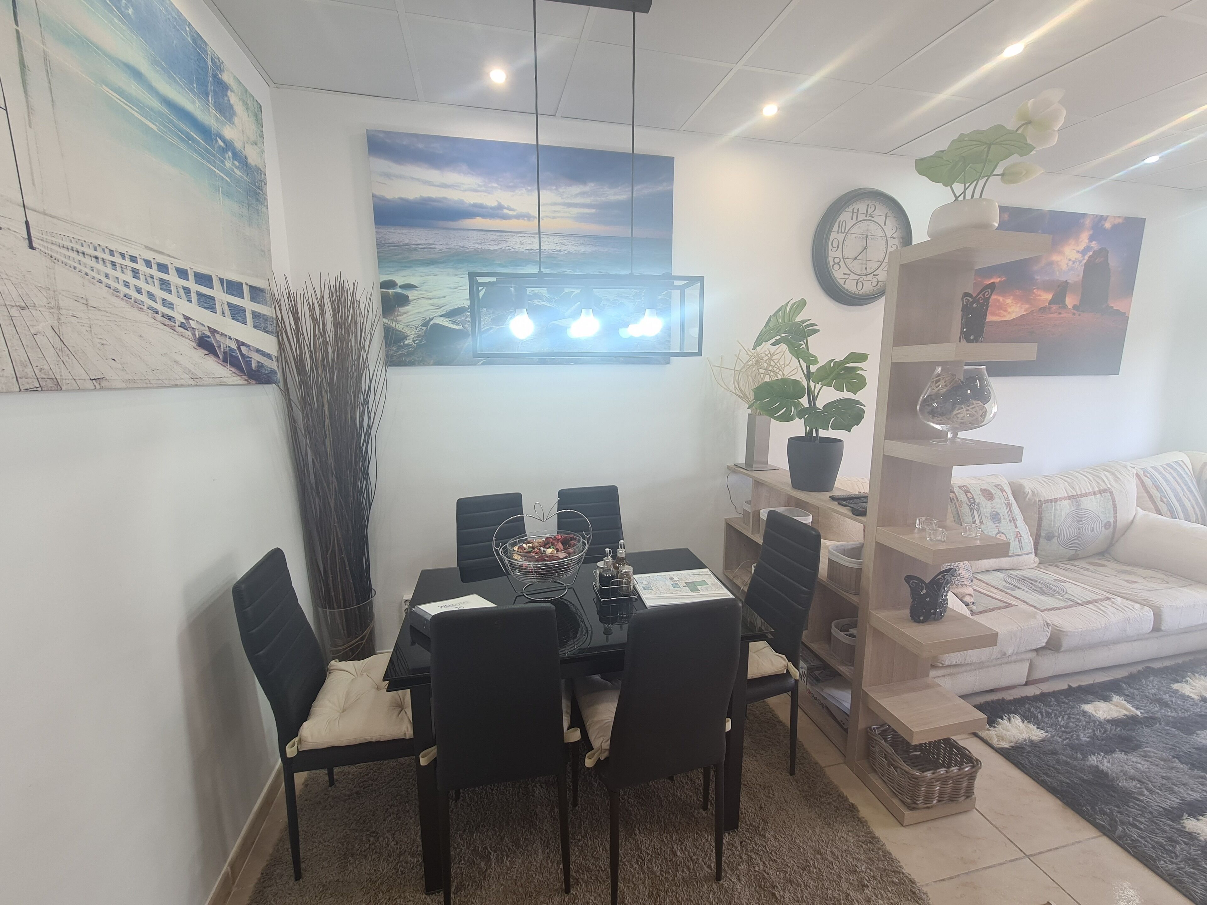A dining area with a table, chairs, and a decorative plant.