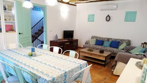 A cozy living room with a dining area, a sofa, and a television. - Rural house with garden and barbecue in the Moncayo area. (Bulbuente)