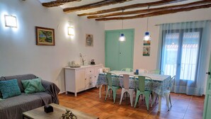 A cozy living room with a sofa, a coffee table, and a dining area with a table and chairs. - Rural house with garden and barbecue in the Moncayo area. (Bulbuente)