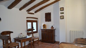 A rustic room with exposed wooden beams, a wooden cabinet, a window, and a radiator. - Rural house with garden and barbecue in the Moncayo area. (Bulbuente)