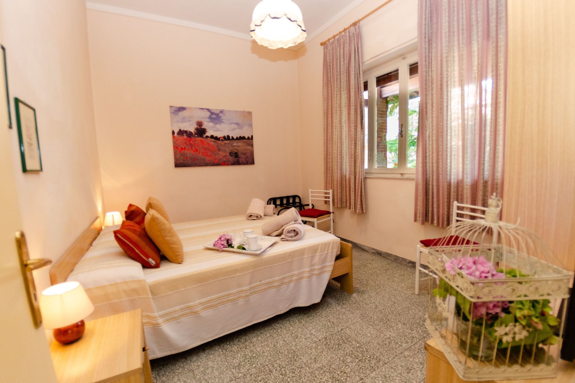 Une chambre confortable avec un lit, une table de chevet, une lampe et un tableau au mur.