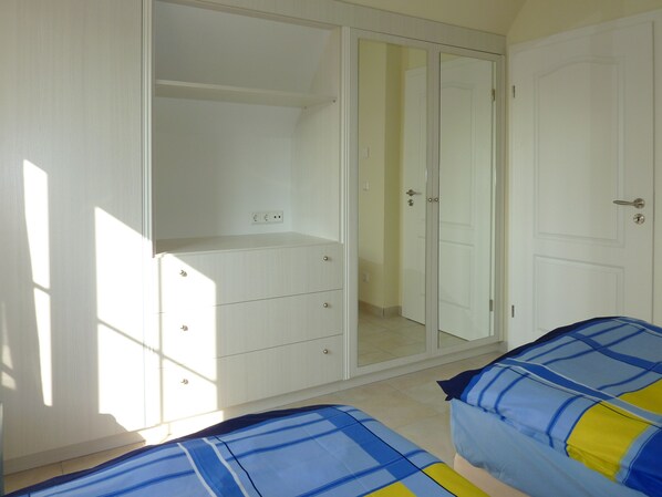 Un dormitorio con armario, cama y puerta.