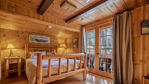 A wooden cabin bedroom with a bed, two bedside lamps, a window with curtains, and a wooden ceiling. - Romantic & private cabin on Rogue River, 1 hr from Crater Lake (Trail)
