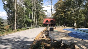 A paved pathway leading to a red-roofed building surrounded by trees. - Cabin on Dale Hollow Lake - Hike to lake (Monroe)