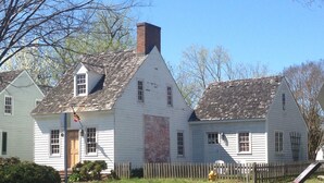 A white colonial-style house with a brick chimney, a wooden picket fence, and a brick pathway leading to the entrance. - John Bruff Waterview Cottage - on Harbor and on Park - In Town St. Michaels! (Saint Michaels)